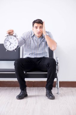 Adam sabırsızlıkla lobide bekliyor.