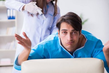 Komik adam şırınga iğnesine hazırlanıyor.