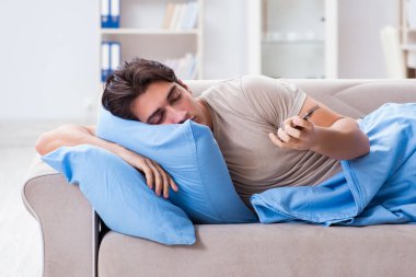 Yatakta cep telefonuna bağımlı bir adam.