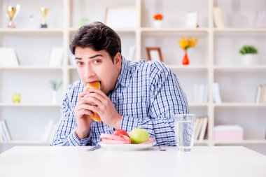 Diyet dolandırıcılığında sağlıklı yemek ve ekmek arasında ikilem yaşayan bir adam.
