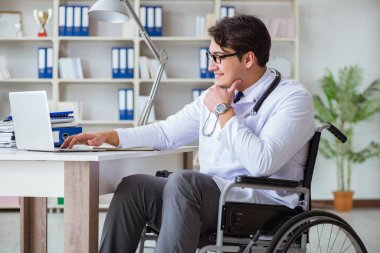 Hastanede çalışan tekerlekli sandalyedeki engelli doktor.