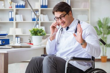 Hastanede çalışan tekerlekli sandalyedeki engelli doktor.