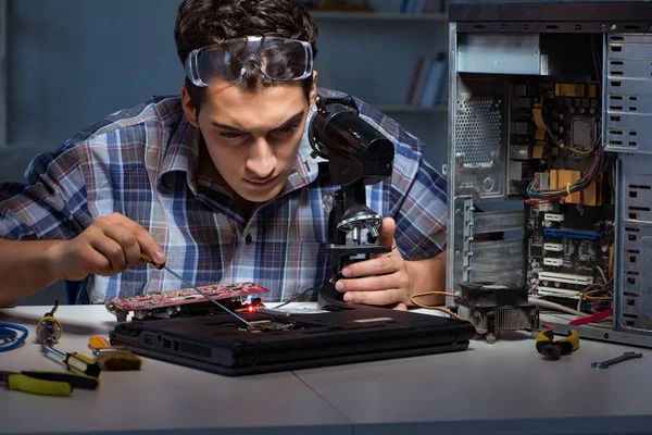 Reparateur versucht Laptop mit Mikroskop zu reparieren — Stockfoto