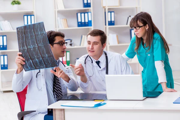 Tres médicos discutiendo los resultados de la exploración de la imagen de rayos X — Foto de Stock