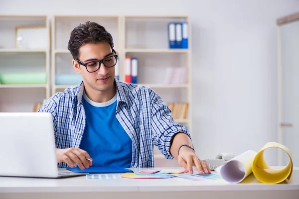 Jovem designer trabalhando em novo projeto e escolhendo cores — Fotografia de Stock