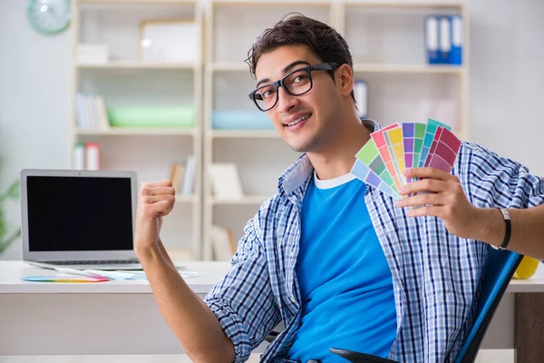 Joven diseñador trabajando en un nuevo proyecto y eligiendo colores —  Fotos de Stock