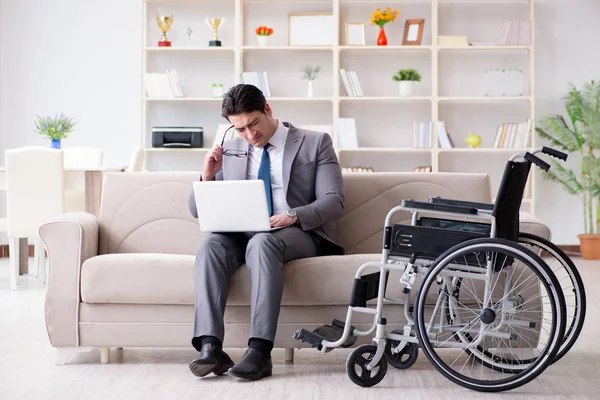 Homme d'affaires en fauteuil roulant travaillant à domicile — Photo
