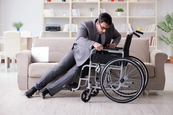 Деловой человек на инвалидной коляске работает дома — стоковое фото