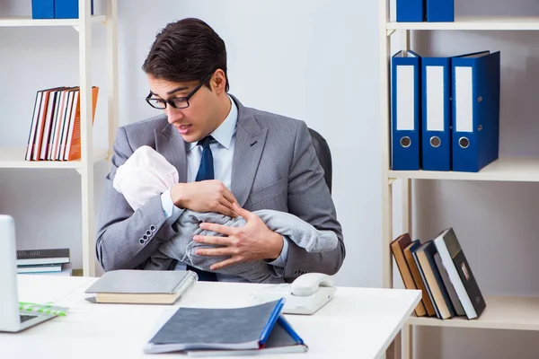 Businessman looking after newborn baby in office — Stock Photo, Image