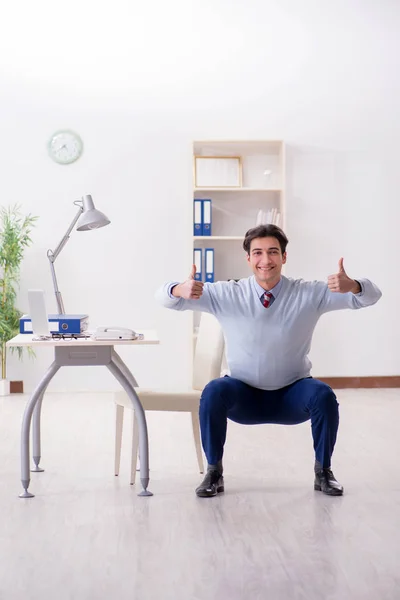 Pracownik wykonujący ćwiczenia rozciągające w biurze — Zdjęcie stockowe