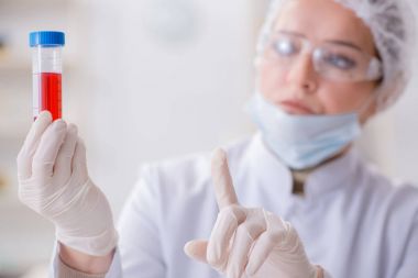 Kadın doktor laboratuvarda kan örneklerini kontrol ediyor.