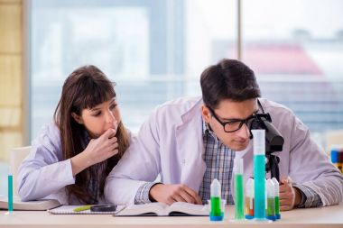 Laboratuvarda deney yapan iki kimyager.