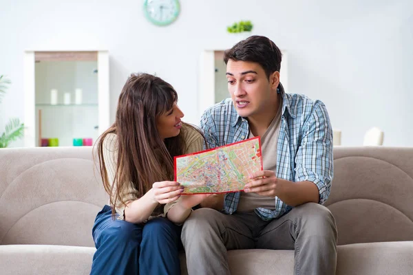 Família jovem discutindo planos de viagem com mapa — Fotografia de Stock