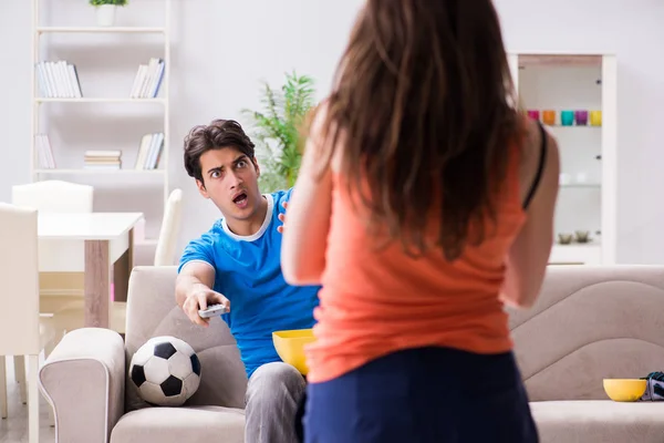 A feleség boldogtalan, hogy a férj focit néz. — Stock Fotó