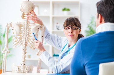 Doktor boynu yaralanan hastaya durumu açıklıyor.