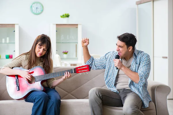 Ung familie synger og spiller musik derhjemme - Stock-foto