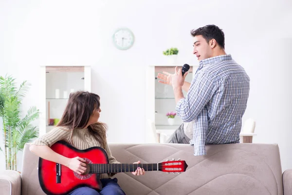 Família jovem cantando e tocando música em casa — Fotografia de Stock