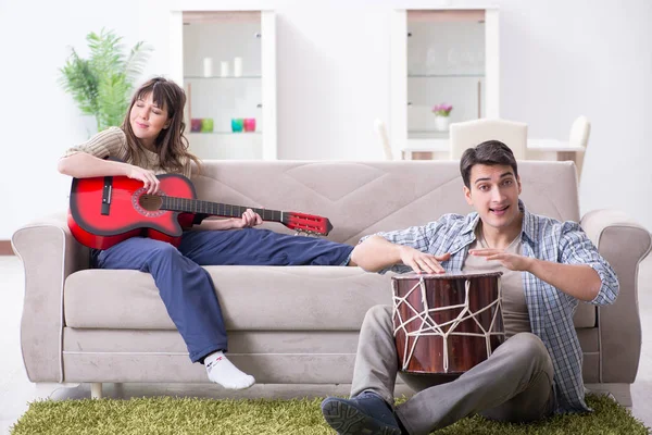 Jonge familie die thuis muziek zingt en speelt — Stockfoto