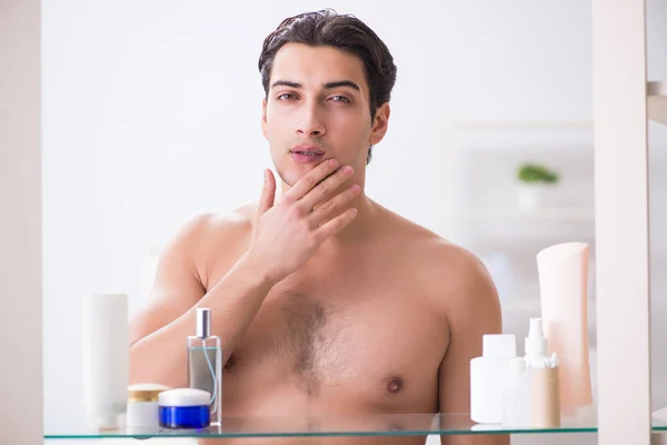 Junger Mann bereitet sich im Badezimmer auf Arbeitstag vor — Stockfoto