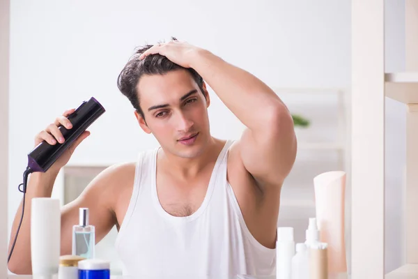 Giovane uomo asciugarsi i capelli al mattino — Foto Stock