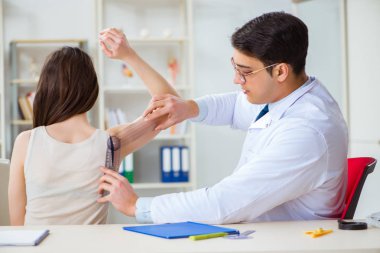 Doktor hastaların eklem esnekliğini gonimetreyle kontrol ediyor.