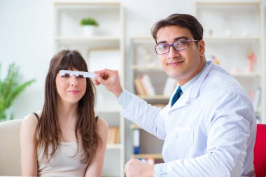 Oftalmolog göz doktoru hastanesindeki hastaları kontrol ediyor.