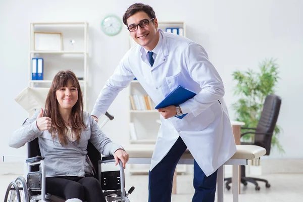 Erkek doktor tekerlekli sandalyedeki kadın hastayı muayene ediyor. — Stok fotoğraf