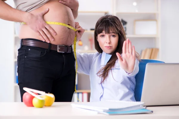 Médico dietista dando consejos a pacientes con sobrepeso de grasa —  Fotos de Stock