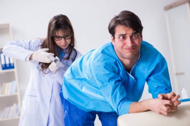 Komik adam şırınga iğnesine hazırlanıyor.