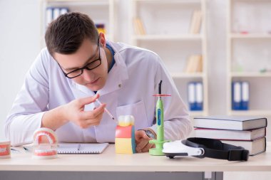 Tıp laboratuarına diş implantı yerleştiren dişçi.