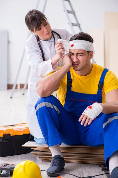 Trabalhador com cabeça ferida e médico — Fotografia de Stock