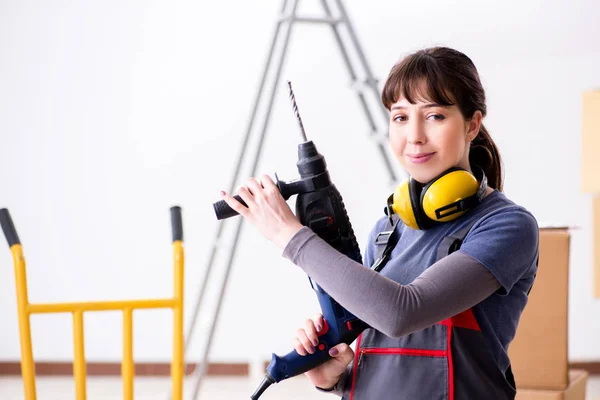 Vrouwelijke aannemer met handboormachine op bouwplaats — Stockfoto