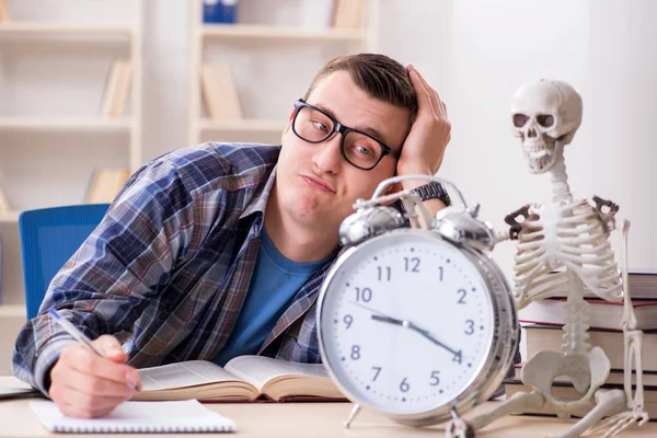 Estudante e esqueleto se preparando para os exames escolares — Fotografia de Stock