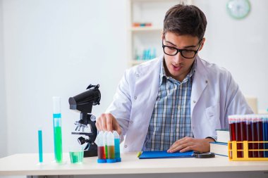 Laboratuvarda kimyasallar üzerinde çalışan genç bir kimyager.