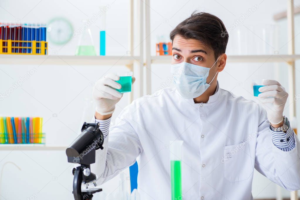 Young chemist student working in lab on chemicals