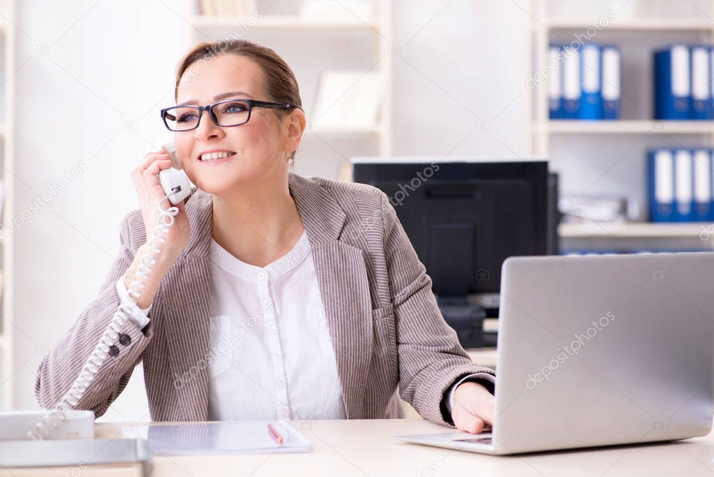 Businesswoman employee talking on the office phone