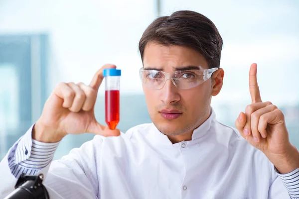 Hombre médico revisando muestras de sangre en el laboratorio —  Fotos de Stock
