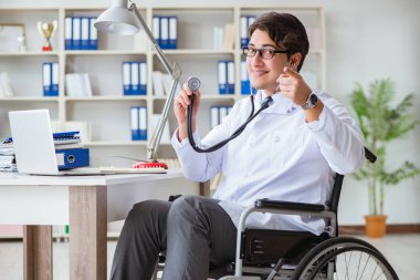 Hastanede çalışan tekerlekli sandalyedeki engelli doktor.