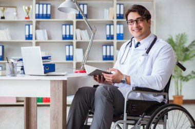 Hastanede çalışan tekerlekli sandalyedeki engelli doktor.