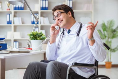 Hastanede çalışan tekerlekli sandalyedeki engelli doktor.