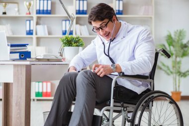 Hastanede çalışan tekerlekli sandalyedeki engelli doktor.