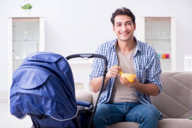 Genç baba yeni doğan bebeğe evde bakıyor.