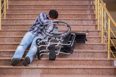 Tekerlekli sandalyedeki engelli adam merdivenlerde sorun yaşıyor.