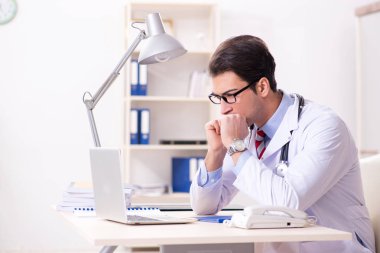 Hastane odasında çalışan yakışıklı genç bir doktor.