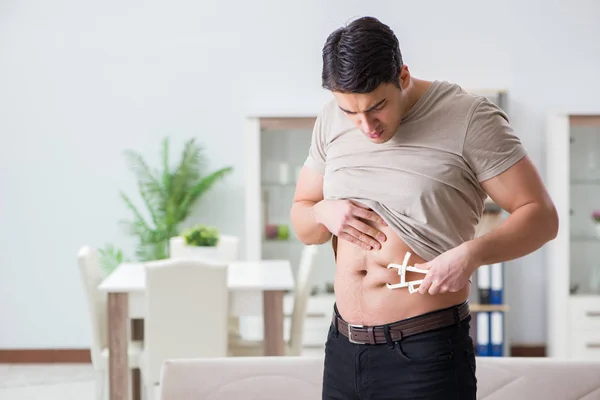 Hombre midiendo grasa corporal con pinzas — Foto de Stock