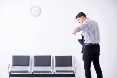 Adam sabırsızlıkla lobide bekliyor.