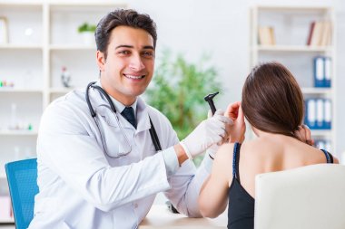 Doctor checking patients ear during medical examination clipart