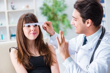 Oftalmolog göz doktoru hastanesindeki hastaları kontrol ediyor.