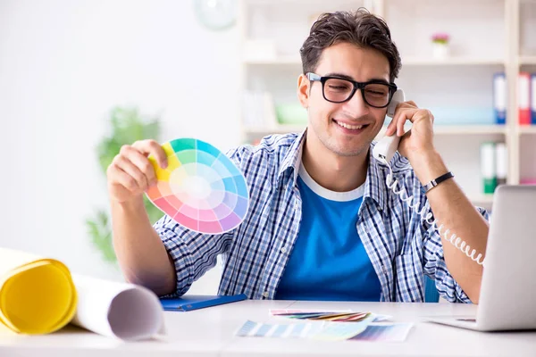 Joven diseñador trabajando en un nuevo proyecto y eligiendo colores —  Fotos de Stock