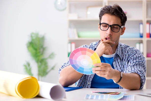 Young designer working on new project and choosing colours — Stock Photo, Image